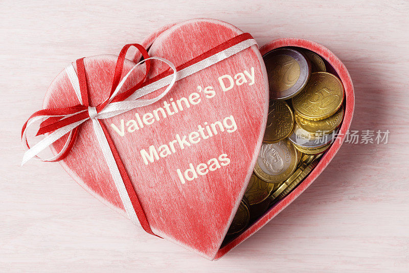 Heart shaped gift box with Euro coins inside and caption Valentineâs Day marketing ideas. Business Ideas concept